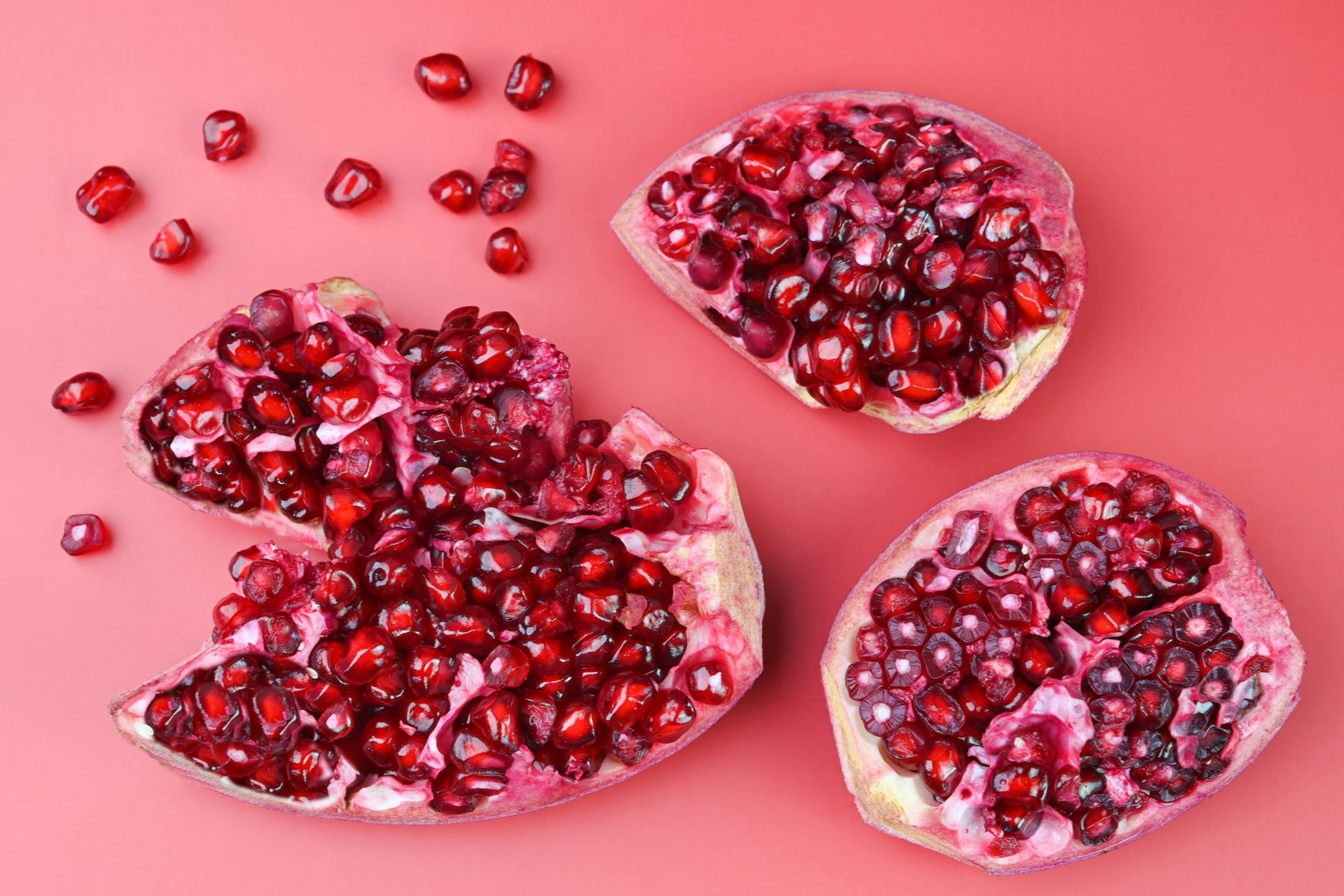 Close-up view of a cut-open pomegranate with its seeds (which are high-protein fruits) spilling out.